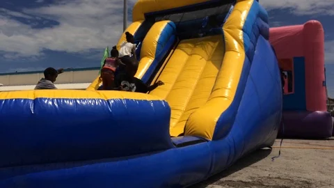 Children Playing and Having Fun in Bounce House, Downtown Freeport Bahamas Stock Footage 94530589