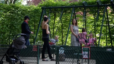 Children playing and having fun on swings at Parc Monceau in Paris France Stock Footage 106402315