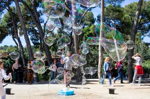 Children playing and having fun with soap bubble at parl guell Stock Photos