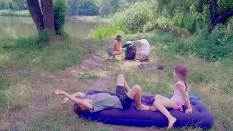 Children playing and laughing while sitting on air mattress outdoors Stock Footage 340464667