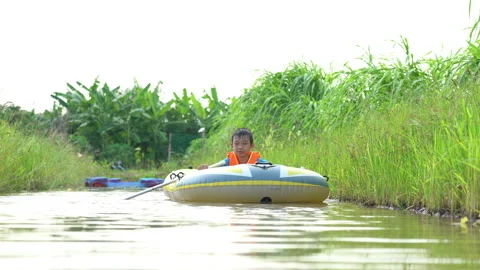 Children playing and rowing boat in river of organic farm in rural 스톡 동영상 183229268