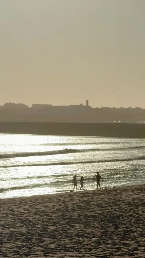 Children playing on Atlantic beach during golden sunset in Portugal 스톡 동영상 339062120