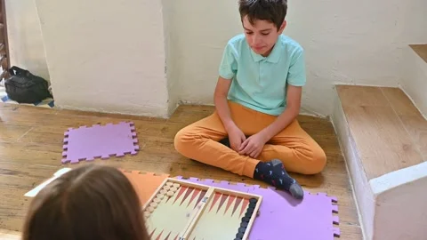 Children playing backgammon on the floor for fun and learning Stock Footage 290052290