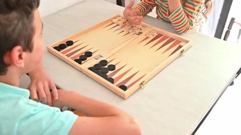 Children playing backgammon at home on a sunny afternoon Stock Footage 290050905