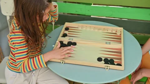 Children playing backgammon outdoors on a sunny day Stock Footage 290053416