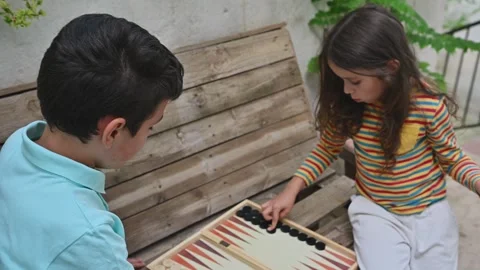 Children playing backgammon outdoors on a sunny day Stock Footage 290053823