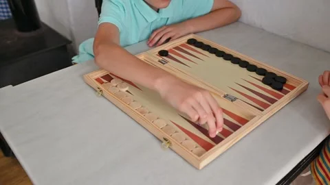 Children playing backgammon at a table top indoor setting Stock Footage 290049719