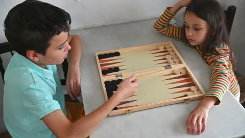Children playing backgammon together at a small table indoors Stock Footage 290050780