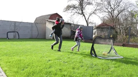 Children playing in the backyard with mother Stock Footage 143712728