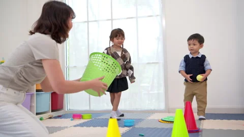 Children playing a ball tossing game into a basket Stock Footage 339568489