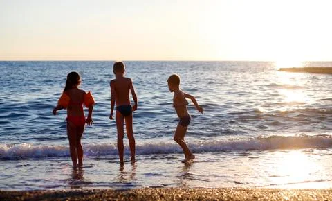 Children playing on the beach during sunset Foto stock