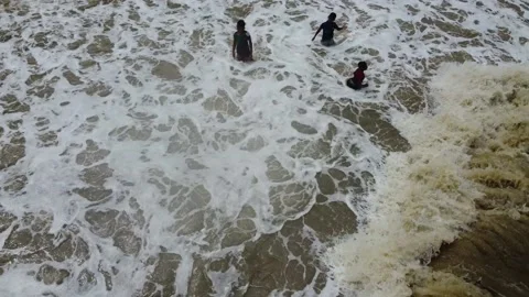 Children playing in the big waves on the beach Stock Footage 145961553