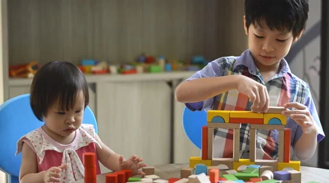 Children playing with blocks on table Stock Footage 52886289