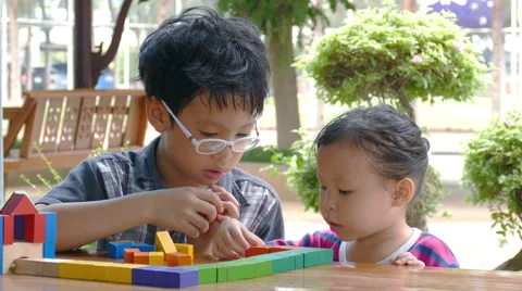 Children playing with blocks on table Stock Footage 64109131