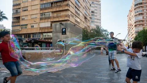 Children playing with bubbles made by bubble artist on streets of Murcia, Spain 写真素材