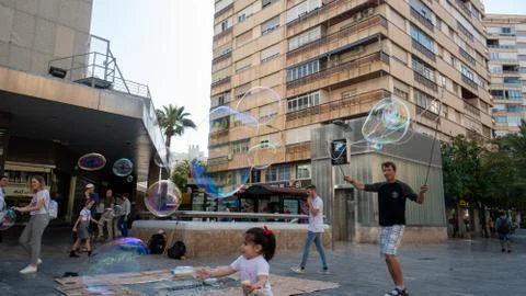 Children playing with bubbles made by bubble artist on streets of Murcia, Spain Stock Photos