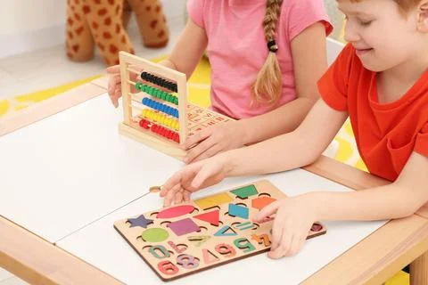 Children playing with different math game kits at desk indoors, closeup. St.. Stock Photos