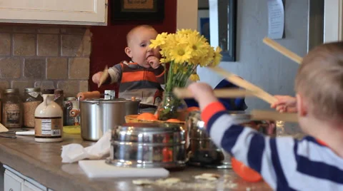 Children Playing Drums on the Kitchen Counter Stock Footage 32677536