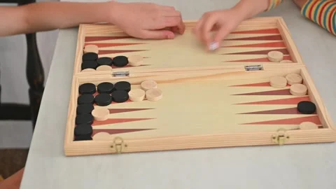 Children playing an engaging game of backgammon indoors Stock Footage 290051971
