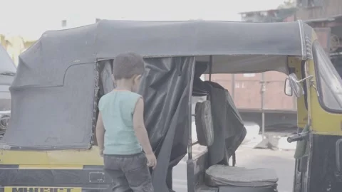 Children playing a game inside a tuk-tuk in Mumbai, India Stock Footage 345388401
