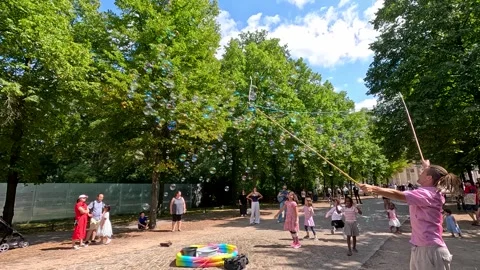Children Playing with Giant Soap Bubbles in Berlin Park Stock Footage 315093890