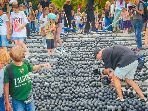 Children playing with hundreds or thousands of black rubber balls Photos