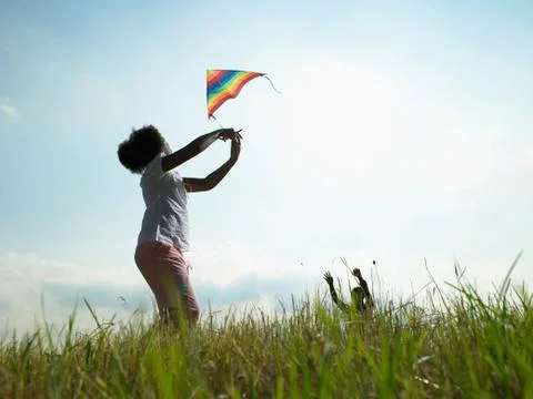 Children playing with kite in field Stock Photos