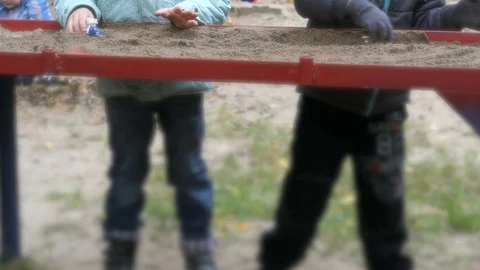 Children playing little cars in sand on table Stock Footage