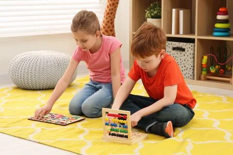 Children playing with math game kits on floor in room. Learning mathematics.. Stock Photos