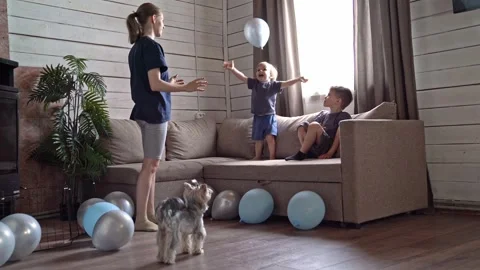 Children playing reflex game with balloons, older sibling guides little ones to Stock Footage 336974640
