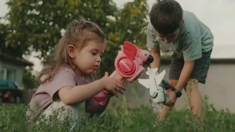 Children playing with soap bubble guns in the garden. Funny boy and girl. 스톡 동영상 252666120