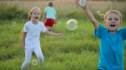 Children playing with soap bubbles Stock Footage 88310761