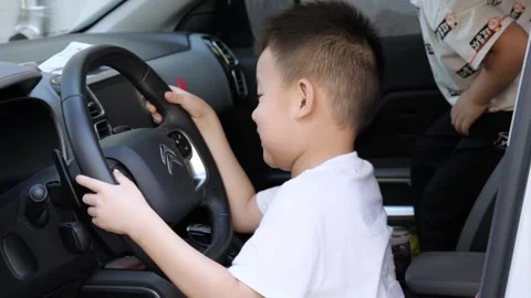 Children playing with the steering wheel in the cab of a Citroen car Stock Footage 221457469