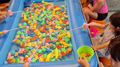 Children Playing Toy Fish Catching Game at Night Market Stock Footage 342720745