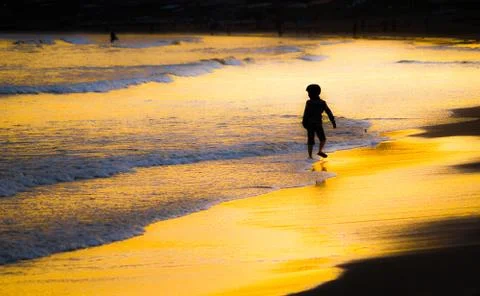 Children playing in the twilight of the beach Stock Photos