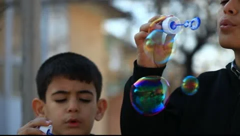 Children playing in water by blowing soap 库存影片 10677975