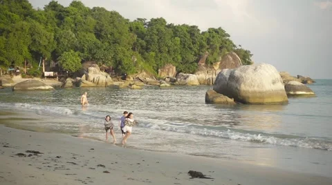 Children playing with water on the coast at sunset. Slow motion Stock Footage 58792053