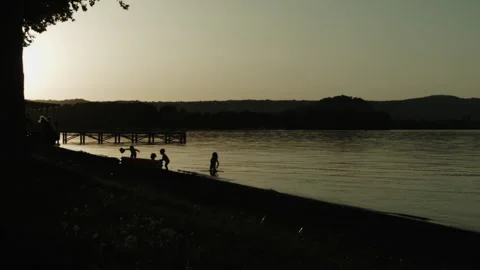 Children playing in the water in the foreground Stock Footage 135050860