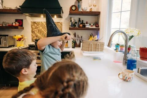 Children playing wizard in kitchen creating magic smoke Stock Photos