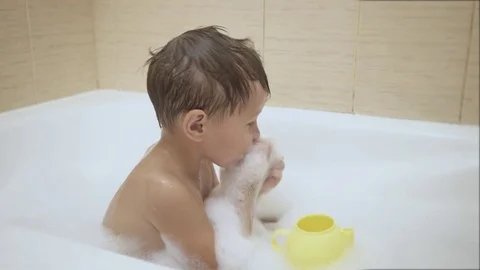 Children plays with bubbles while taking a bath Stock Footage 77260790