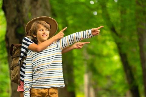 Children Pointing in Forest While Hugging Foto stock