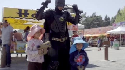 Children posing with superhero costume performer at outdoor festival in Cholula Stock Footage 342279861