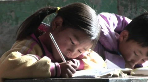 Children practice writing in a rural classroom in China. Stock Footage