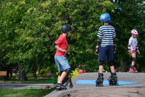 Children Practicing Inline Skating and Scooter Riding on Pump Track Stock Photos