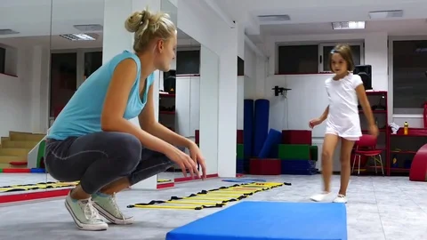 Children practicing somersault under the supervision of trainer. Stock Footage 83625571