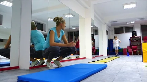 Children practicing somersault under the supervision of trainer. Stock Footage 83628565