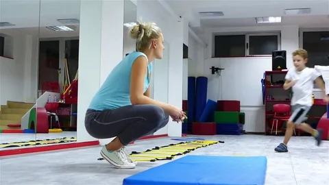 Children practicing somersault under the supervision of trainer. Stock Footage 83628606