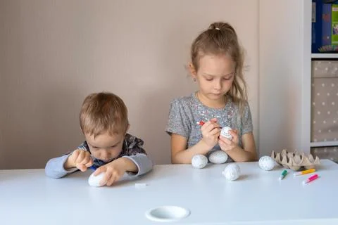 Children prepare for Easter, coloring decorative eggs Stock Photos