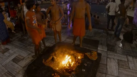 Children of priests in front of the sacred bonfire Ganges embankment with believ Stock Footage 107558844