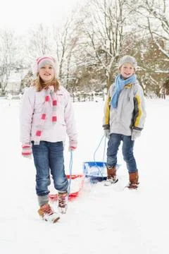 Children Pulling Sledge Through Snowy Landscape Stock Photos